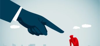 Photo of illustration of giant finger blaming person who is sitting.