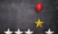 Stars with red balloon lifting one against a chalkboard background